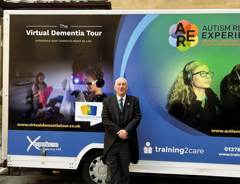 The Speaker of the House of Commons beside the Virtual Dementia Tour bus